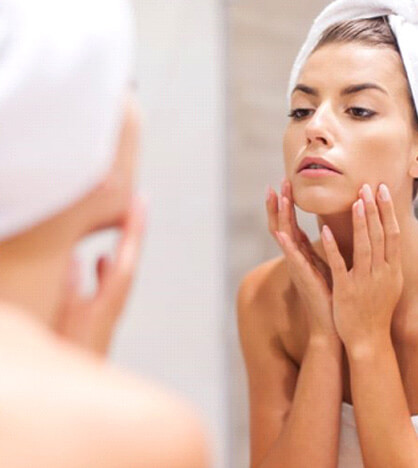 Woman standing infront of mirror, looking for wrinkles