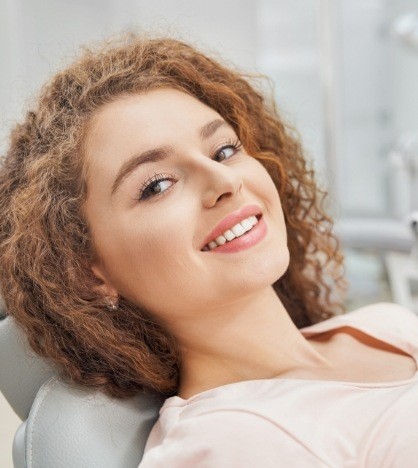 Smiling woman leaning back in dental chair