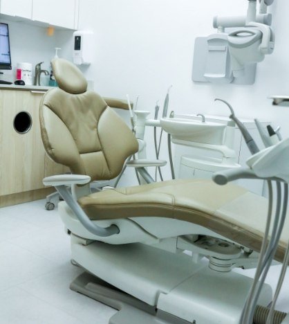 Dental treatment room with X ray machine and other dental technology in background