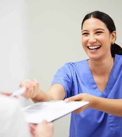 Dentist handing patient paperwork