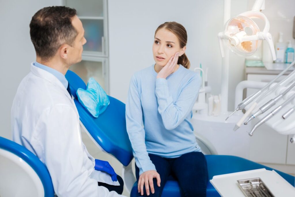 A woman discussing tooth pain with her dentist.